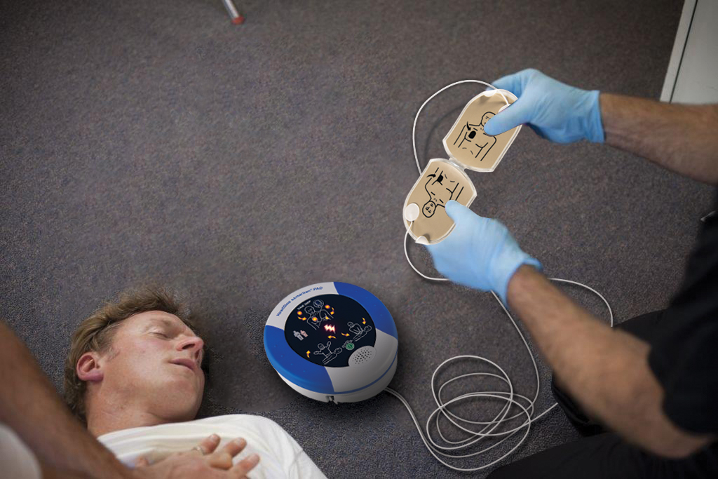 Heartsine Defibrillator being demonstrated on a patient lying on the floor