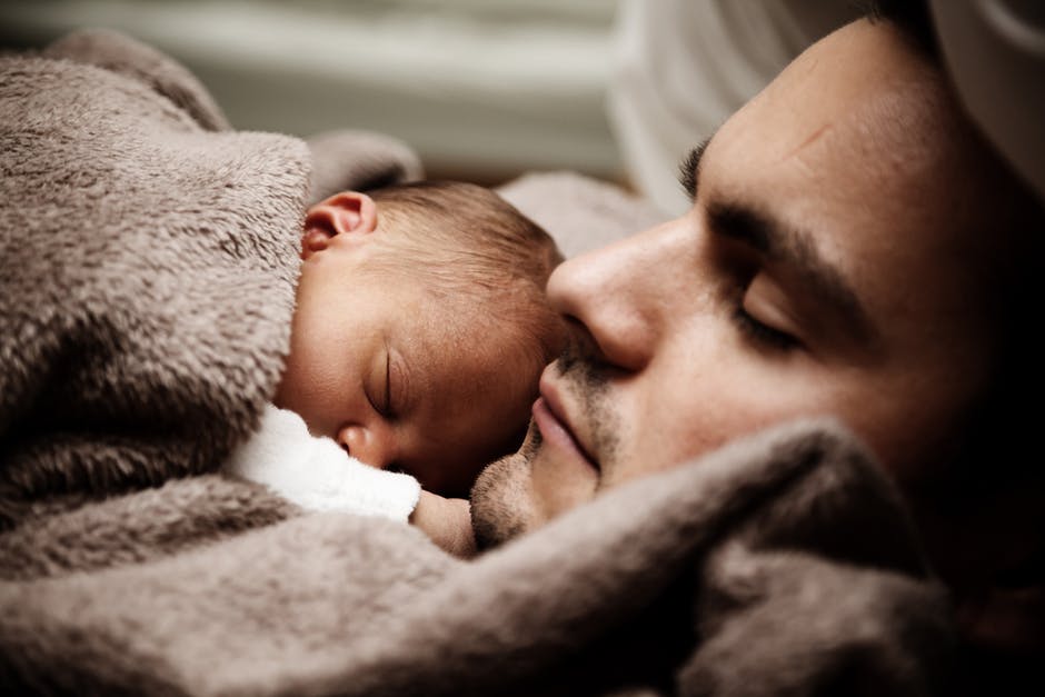 Father sleeping with new born son