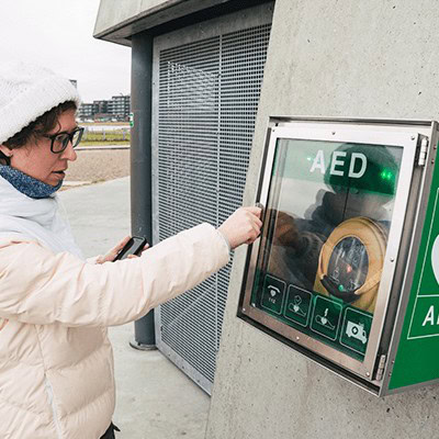 Woman Accessing Defibrillator in a public place