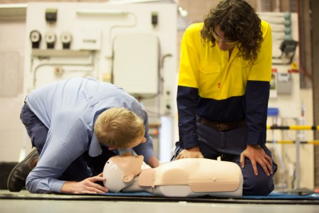 2 People performing Workplace First aid and CPR training on CPR dummy