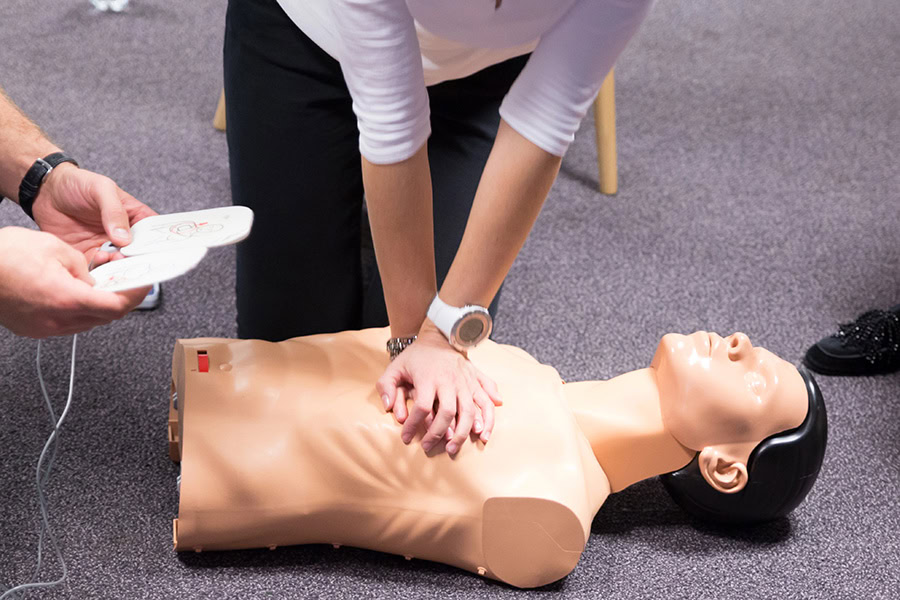 Student practising AED use during first aid training session